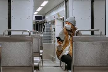 Woman in a mask sitting on the subway