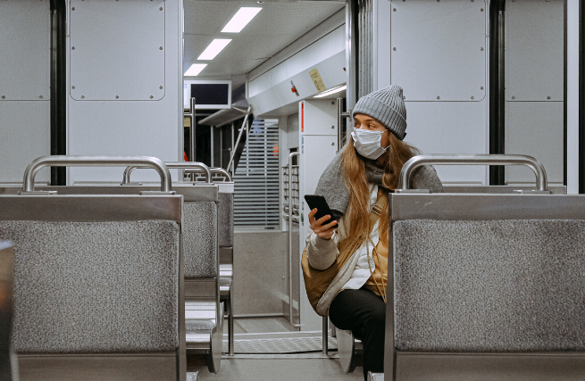 Woman in a mask sitting on the subway