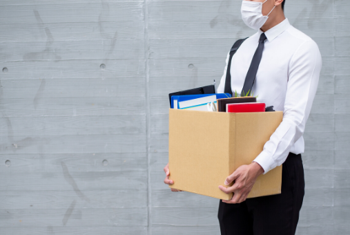 Man in a mask holding a box full of files