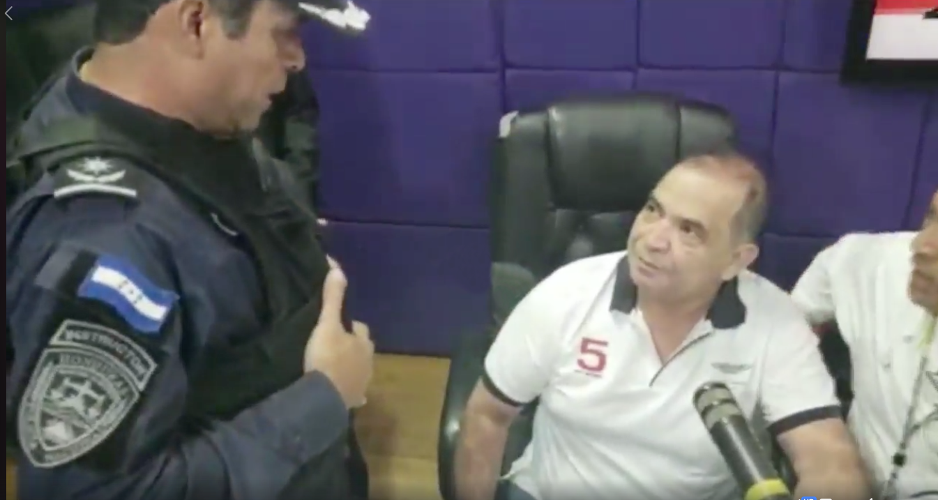 Honduran journalist David Romero is arrested after police raid his radio station Radio Globo. (Screenshot from Radio Globo video on Facebook)