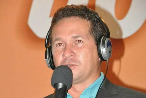 Jairo Sousa wearing headphones and at a microphone