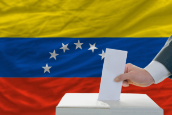 Venezuelan flag with ballot box and hand putting in white sheet of paper
