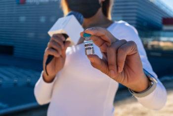 Reporter holding a COVID vaccine vial