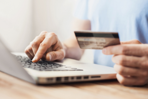 Person on a laptop with a credit card in hand