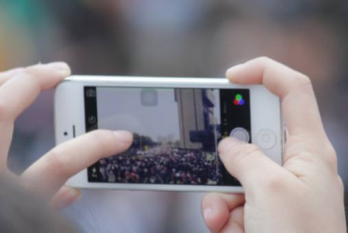 Person with phone taking photo of a march