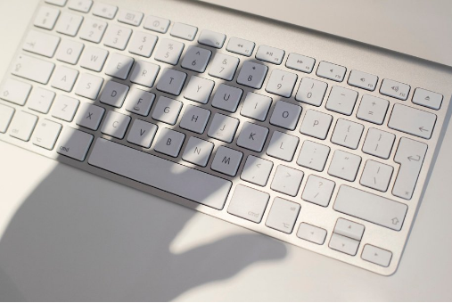 Shadow of a hand on a computer keyboard