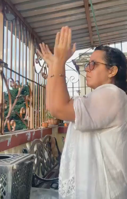 Cuban journalists Camila Acosta claps during her house arrest in Havana.