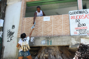 Person passing out a paper in a favela