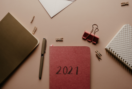 Work items scattered on a desk with a 2021 calendar