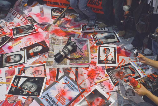 Photos of murdered Mexican journalists scattered on the ground during a protest