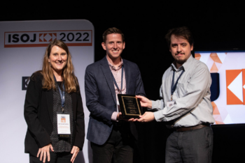 A woman and two men share ISOJ research award on stage