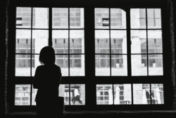 Person standing looking out a window