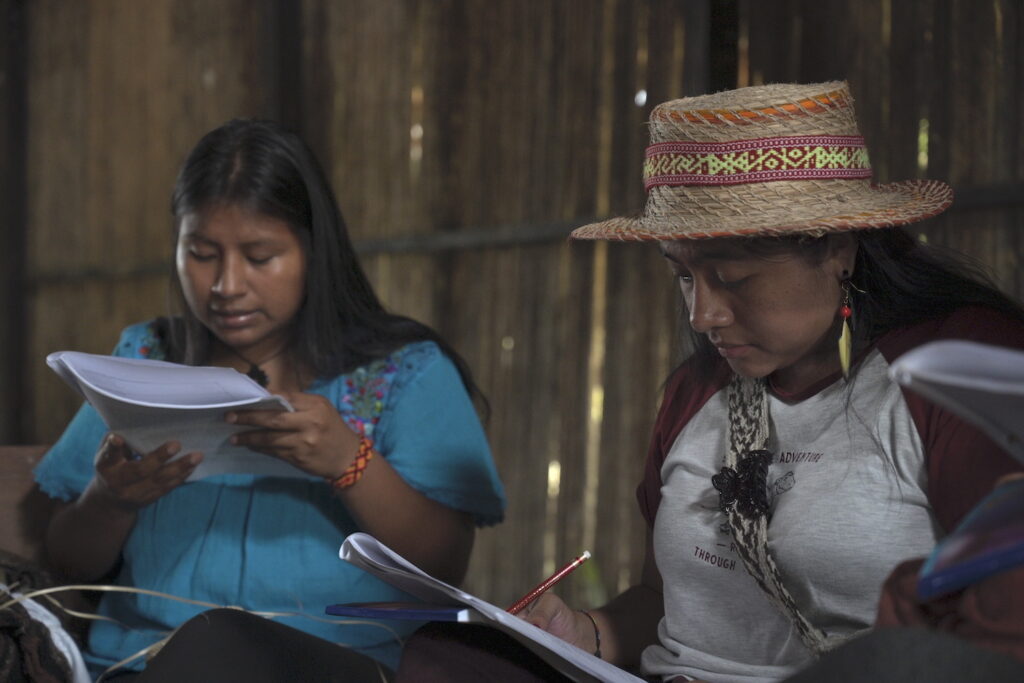 Dos mujeres indígenas leen el documento Manifiesto por la palabra liderado por Agenda Propia. (Foto: Vanessa Teteye / Cortesía)