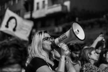 Woman talking at a speaker during feminist march