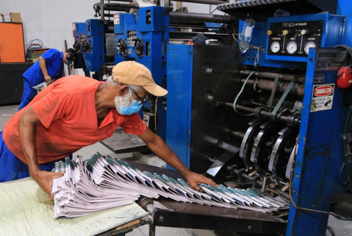 Cooperativas. Membro da cooperativa recolhe jornal recém impresso. O maquinário pertencia aos antigos donos do jornal. (Foto: cortesia Tribuna Independente)