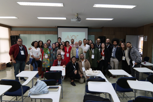 Ajor's team gathered at a classroom with a screen with Ajor's logo behind them