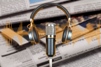 Microphone and headphones over several newspapers.