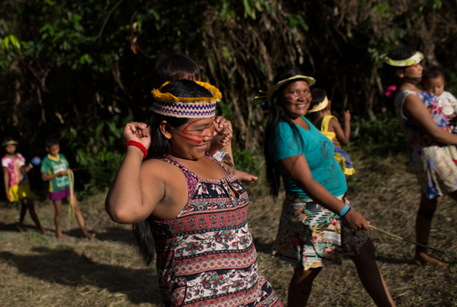 indigenous women walking carrying children and smiling