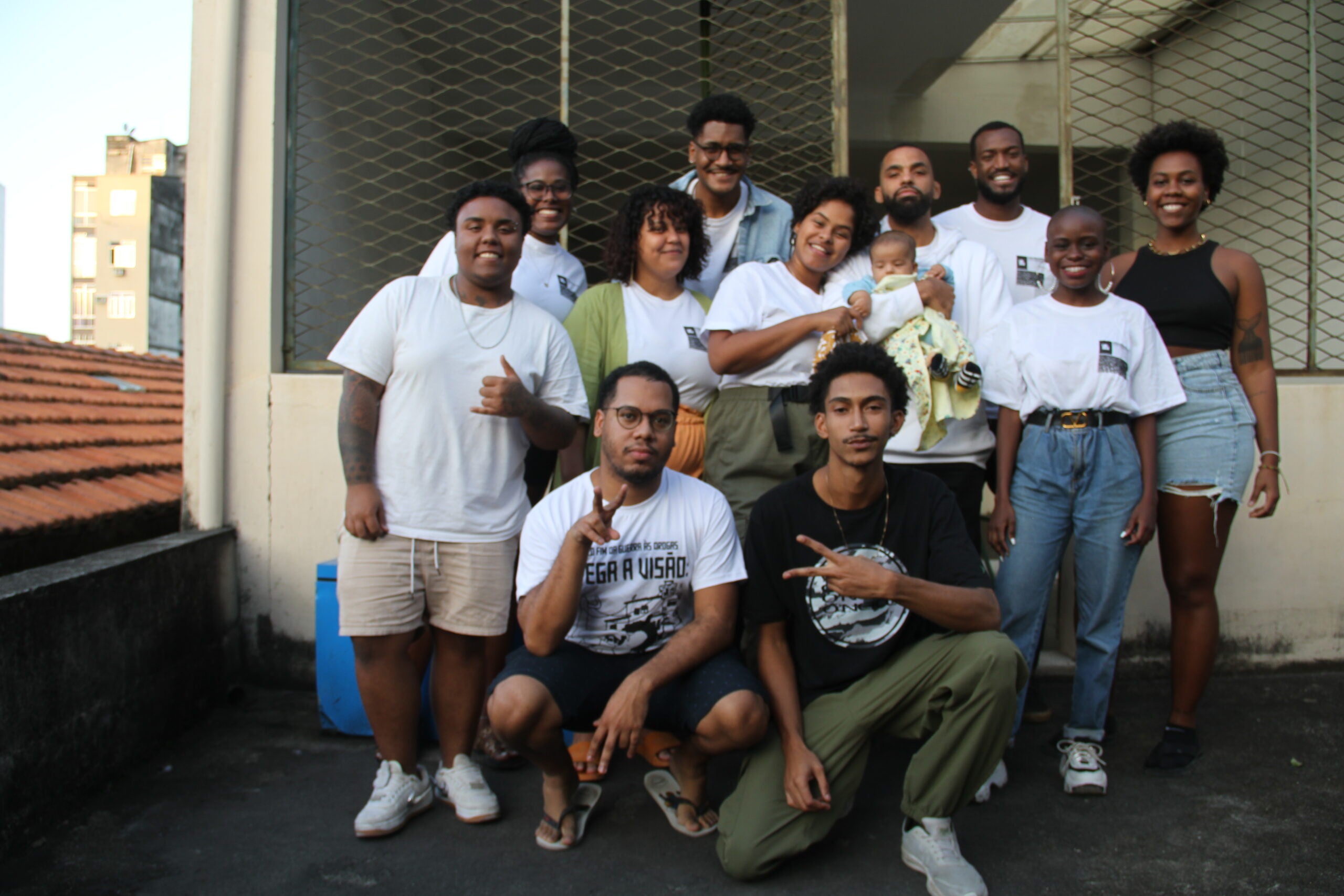 group of young people facing the camera, one holding a baby