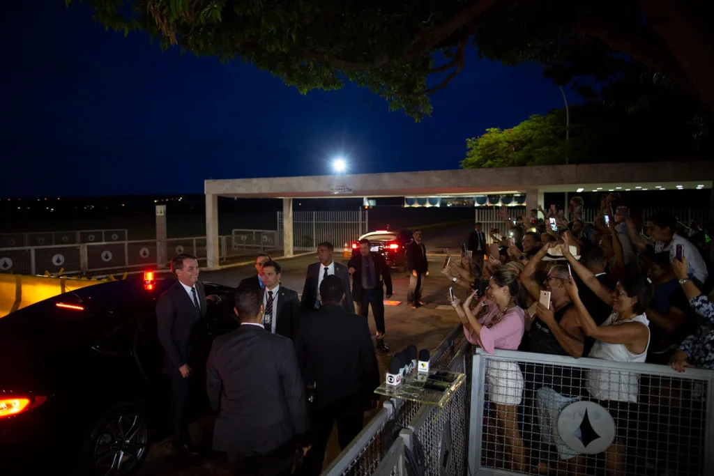 Bolsonaro leaves his car in front of supporters gathered in fenced area