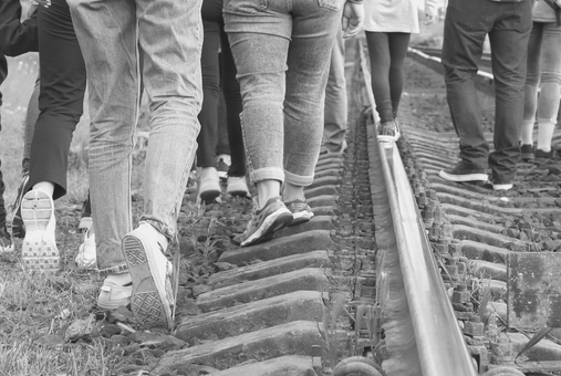 Migrants walking on train tracks.