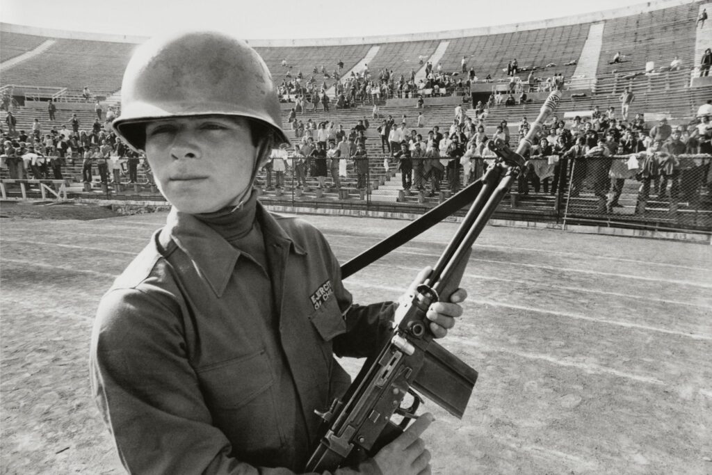Soldado armado frente a presos políticos en el Estadio Nacional de Chile en 1973