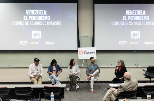 Five people on stage in front of a screen to discuss the situation of press freedom in Venezuela