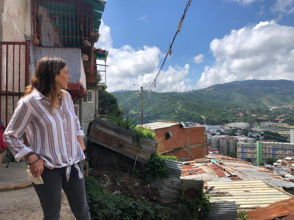 Mulher no alto de uma favela