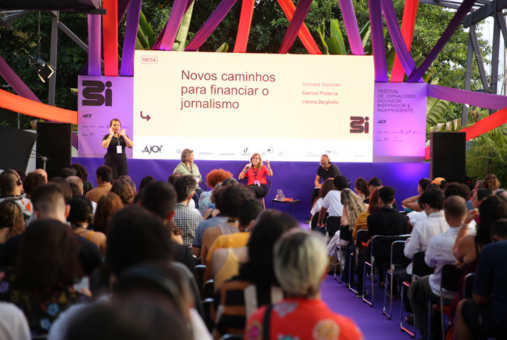 two white women and one black man sitting in front of an audience