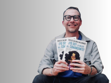 a young man smiling and holding two books