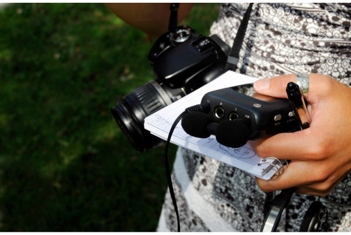 a journalist holding a notebook, camara and recording