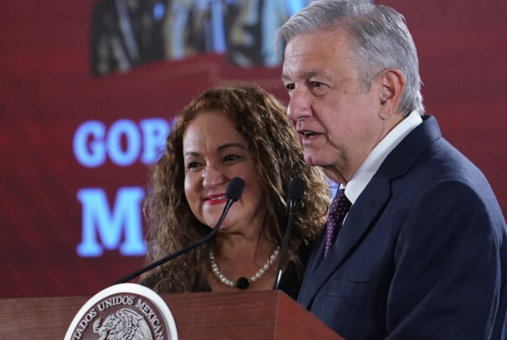 woman with long curly hair next to man with silver hair behind a presidential pulpit