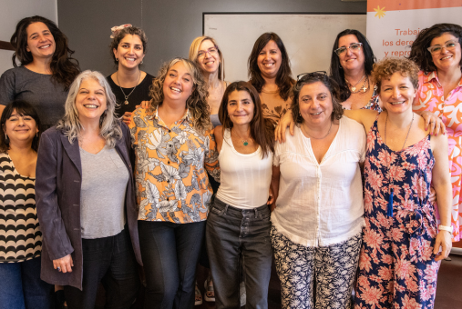 12 mujeres en grupo posan frente a la cámara