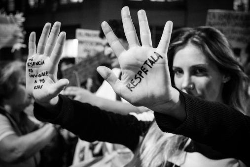 woman holding her hands up asking for respect during feminist demonstration