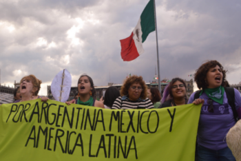 five women hold banner during women's march in mexico city