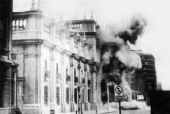 Black and white photograph capturing the moment of the bombing of La Moneda Palace, the seat of the Chilean government, during the 1973 military coup. Smoke and debris are visible, symbolizing a pivotal and tragic moment in Chilean history.