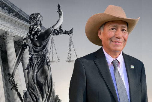 Mexican journalist Emilio Gutiérrez Soto poses with a background of a justice sculpture and a court building.