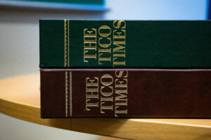 Two volumes of The Tico Times, one red and one green