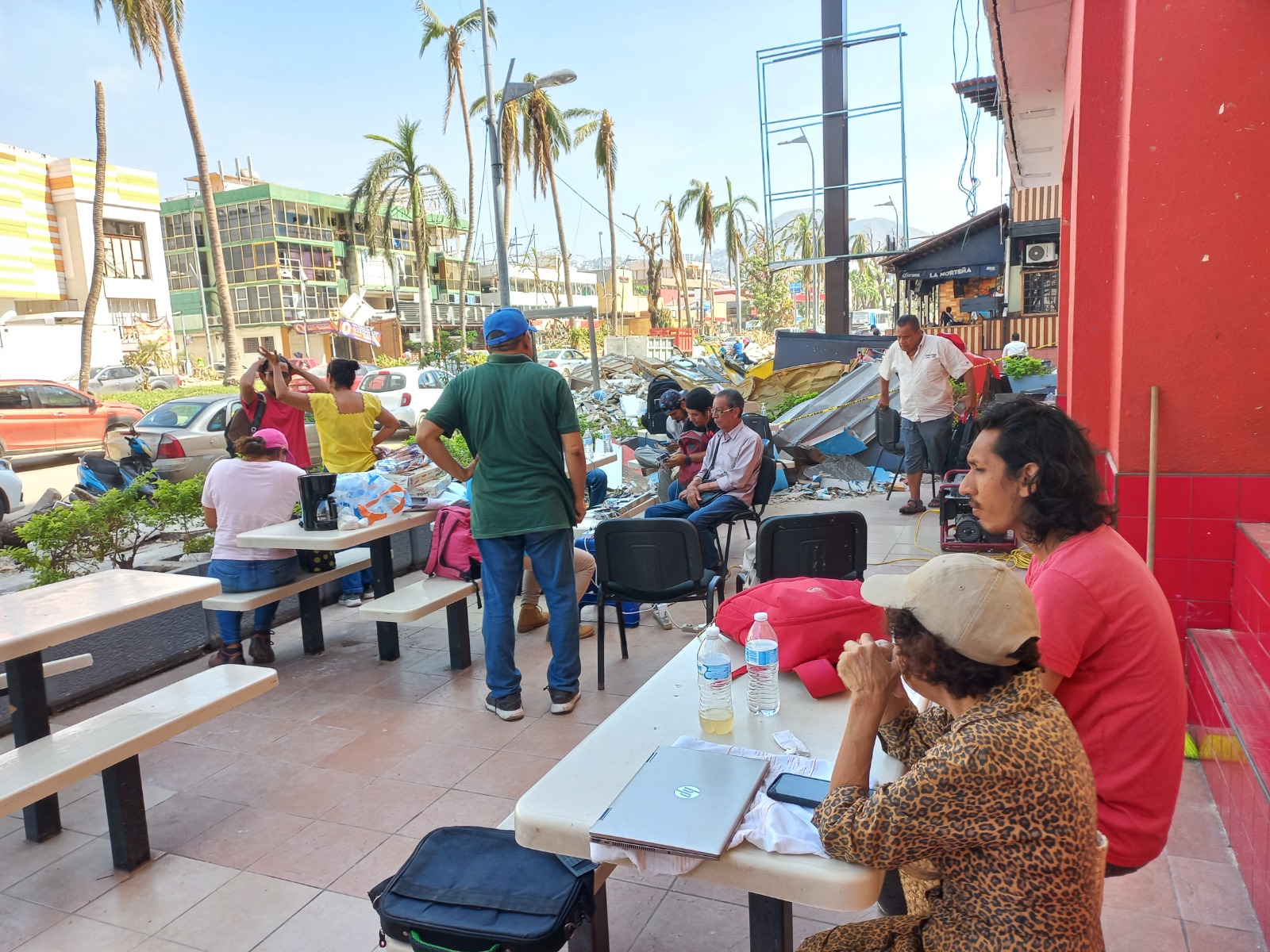 A group of journalists gathered at the outdoors area of a restaurant in Acapulco.