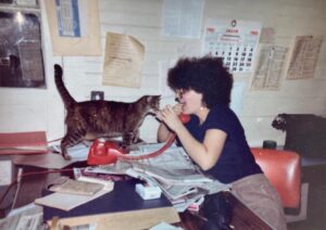 Woman on a red phone playing with a cat