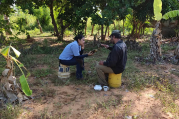 a journalist talking to a source in a field