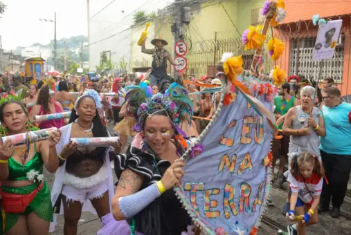 Women dressed in costumes and carrying musical instruments dance during the parade of the Céu Na Terra block in Rio de Janeiro on February 3, 2024