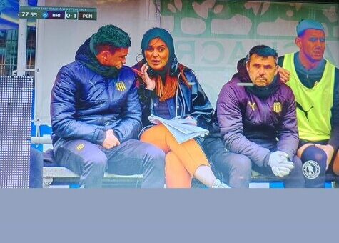 ruguayan journalist Ana Inés Martínez seeks refuge on the bench after being targeted with thrown objects during the Peñarol versus Boston River match in Montevideo, highlighting the dangers journalists face while covering sports events