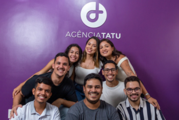 Agência Tatu team gathered in front of a purple wall