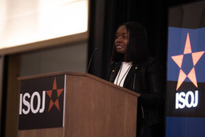 Mujer afrodescendiente frente un podio hablando durante ISOJ