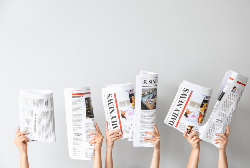 hands holding up newspapers