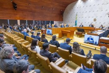 Uma foto da Sala do Supremo Tribunal Federal no Brasil, com juízes sentados ao fundo e pessoas observando um julgamento.