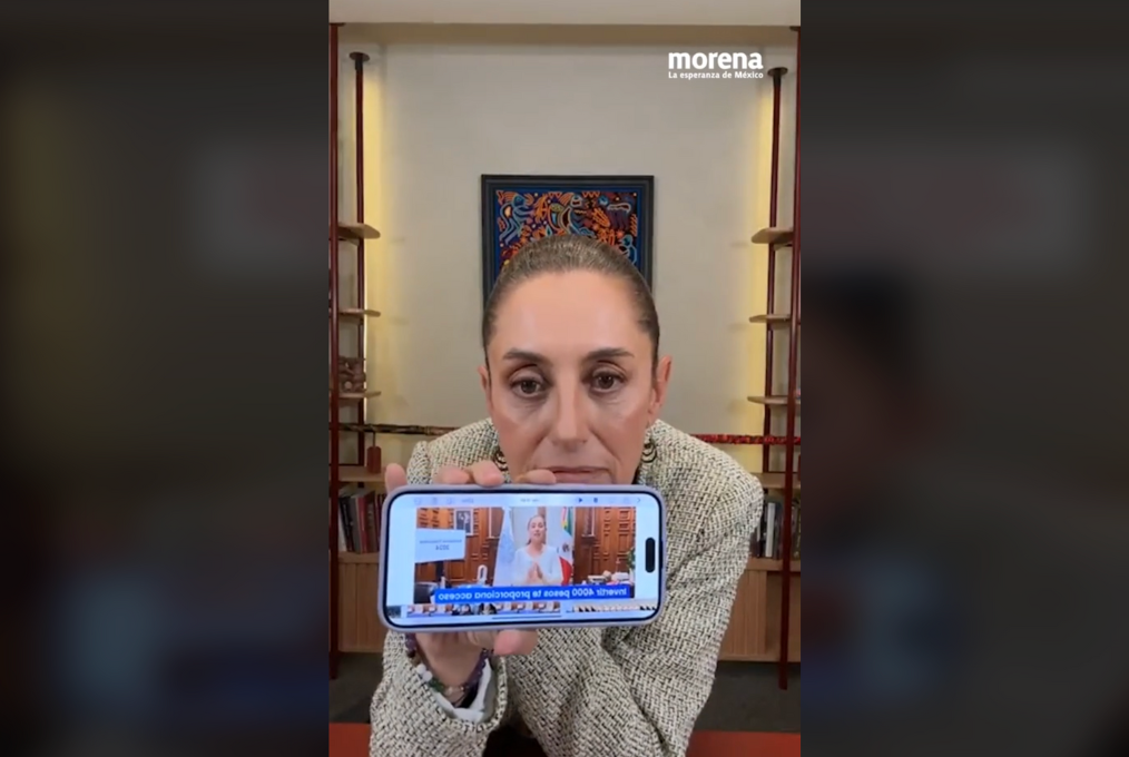 Mexico's President-elect Claudia Sheinbaum shows a manipulated video of her on her mobile phone.