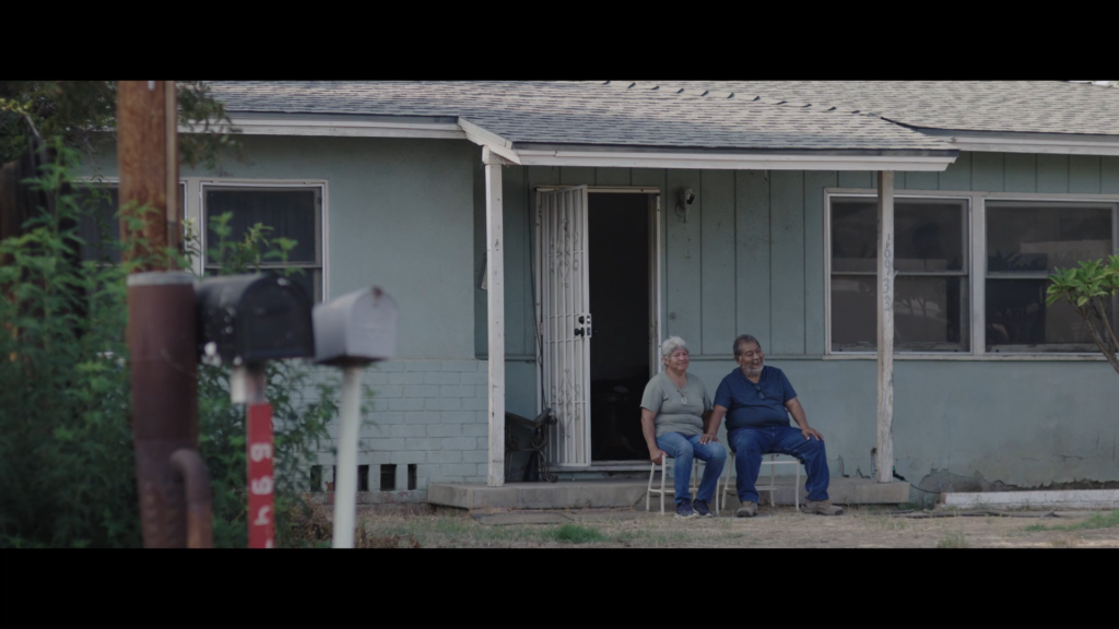 a woman and a man sitting in front of a house