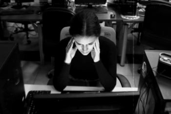 woman staring at computer screen in a newsroom